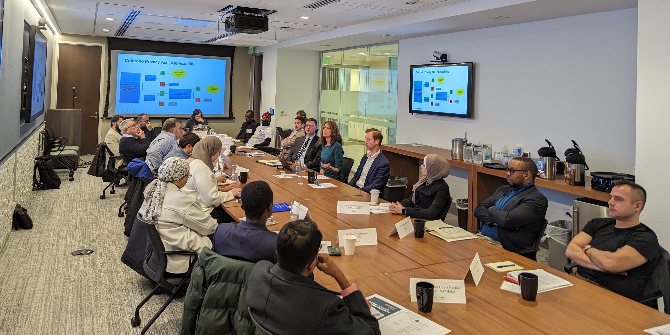 IVLP participants and employees of the Colorado Attorney General’s Office sitting at a table listening to a presentation.